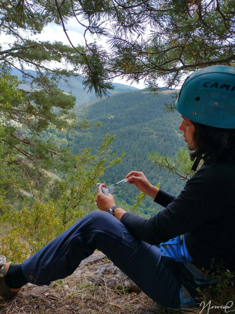 Woman painting on a small book at the mountains 